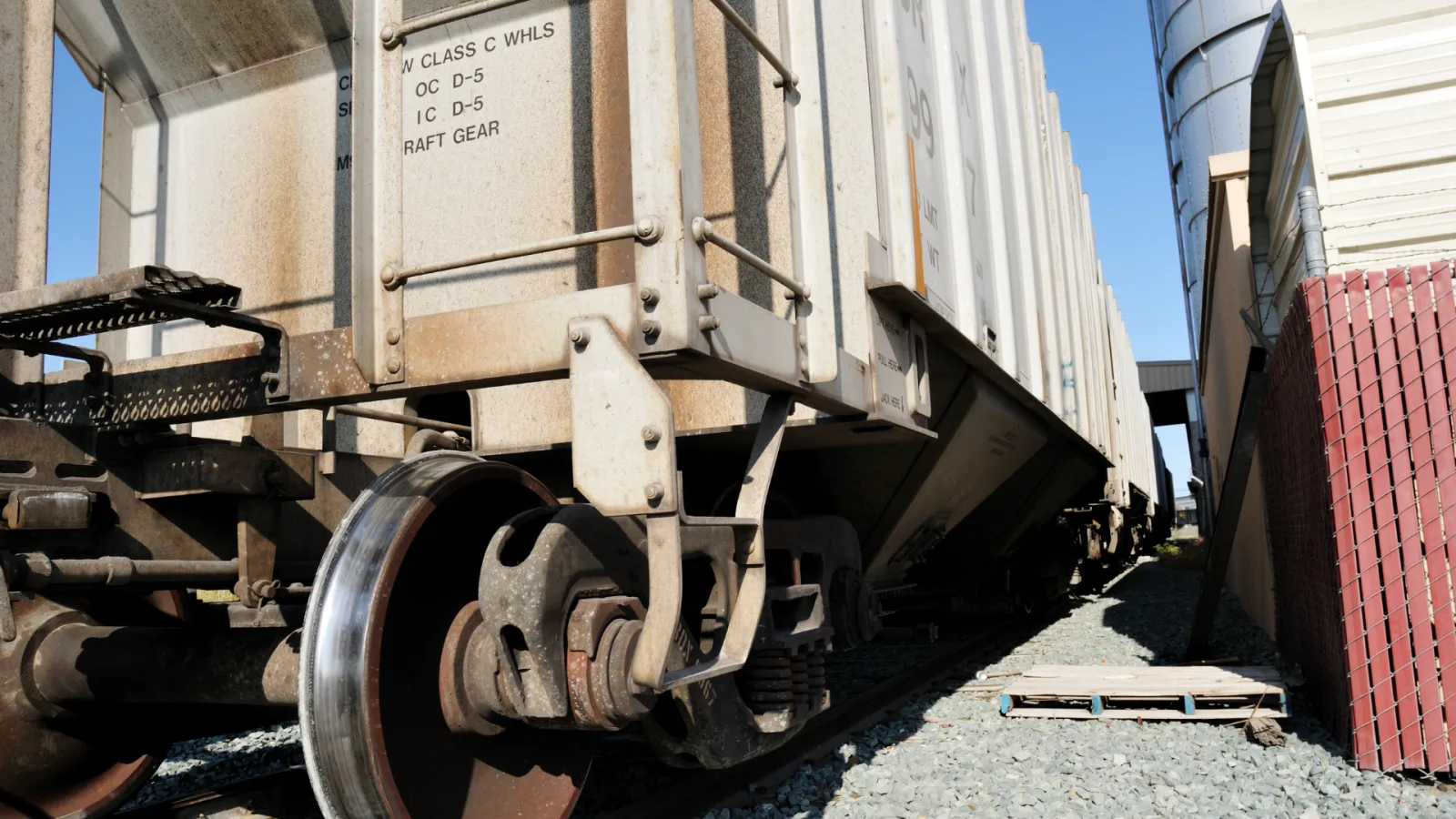Freight railcars alongside an industrial facility