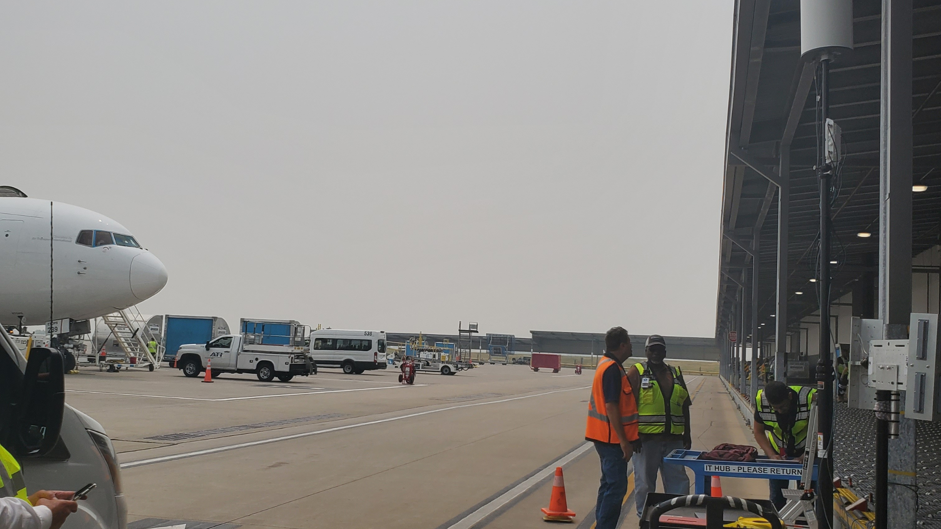 Airport ramp with aircraft, ground crews and mounted wireless equipment